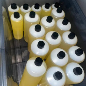 100% pure raw THC oil bulk supply, stored in white plastic bottles with black caps inside a grey storage crate.